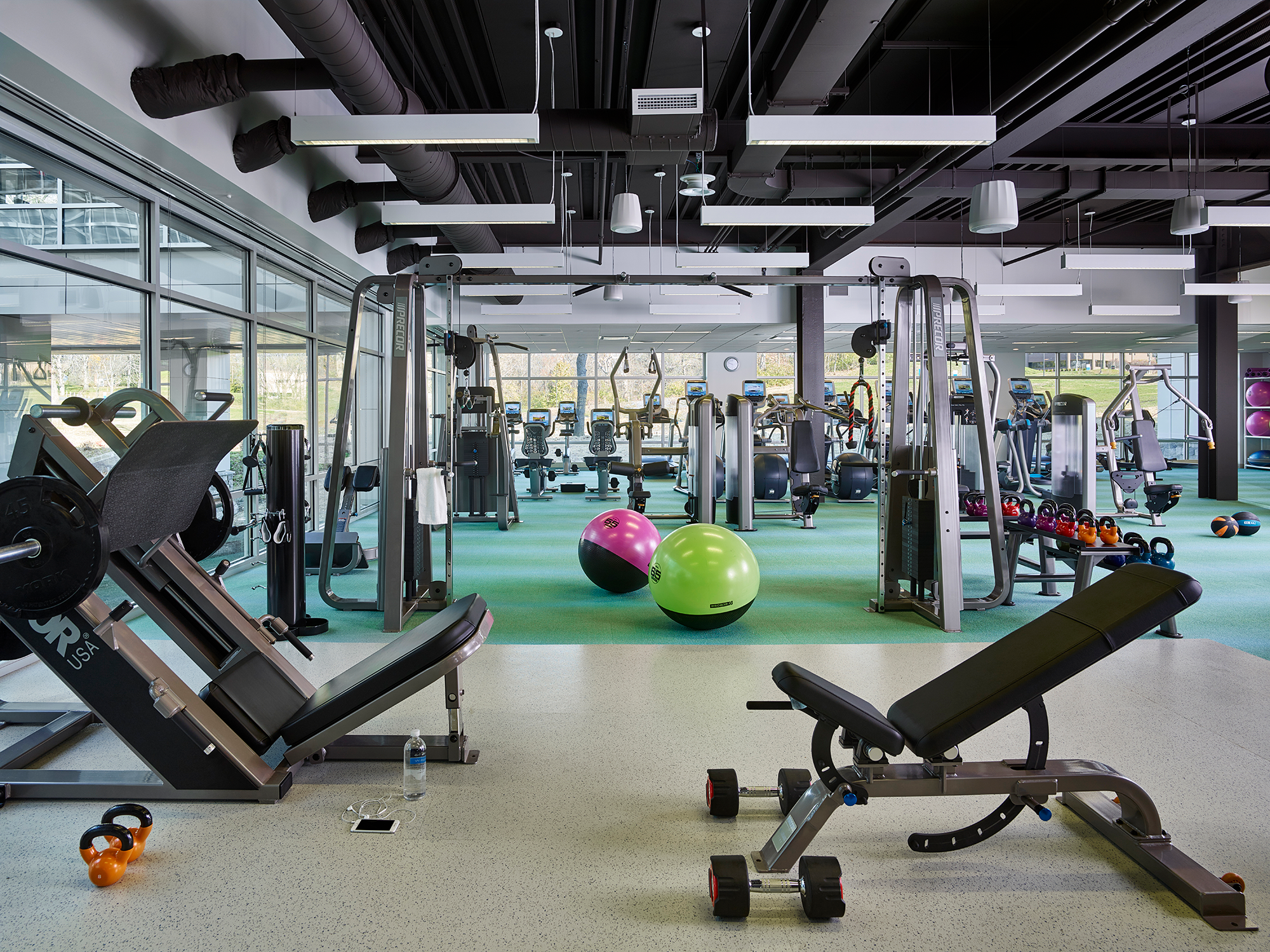 A state-of-the-art indoor gym with weight training equipment, ellipticals, treadmills, and exercise balls.