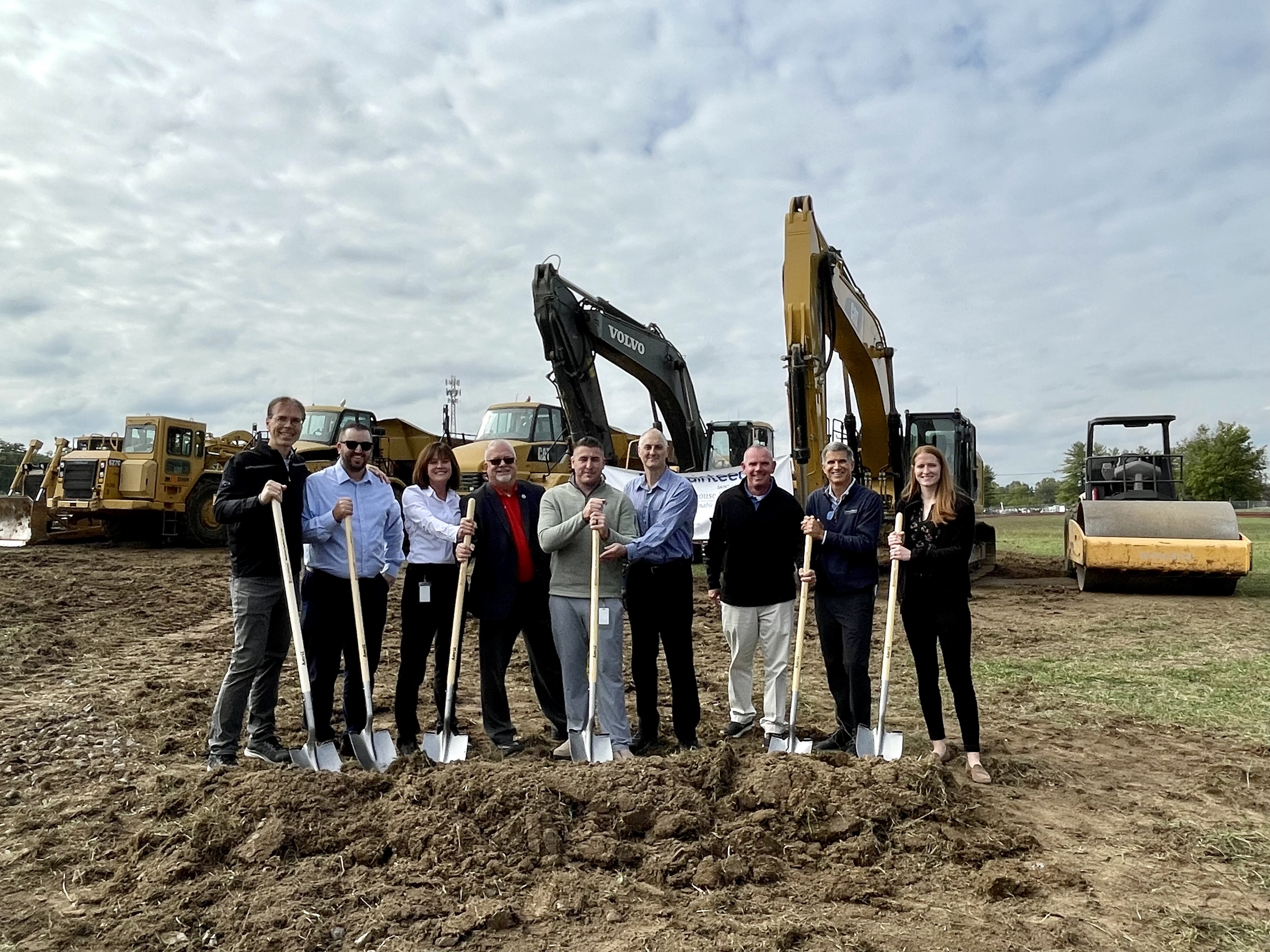 /group%20of%20people%20with%20shovels%20at%20groundbreaking%20ceremony%20in%20front%20of%20machinery